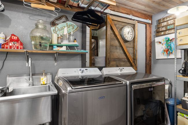 Laundry area featuring washing machine and clothes dryer and a barn door | Image 34