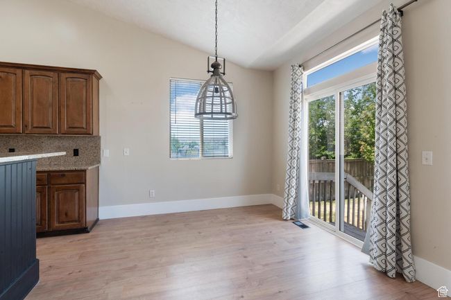 Unfurnished dining area featuring vaulted ceiling and light wood-style flooring | Image 14