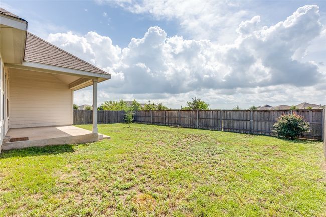 Fenced backyard with a patio | Image 22
