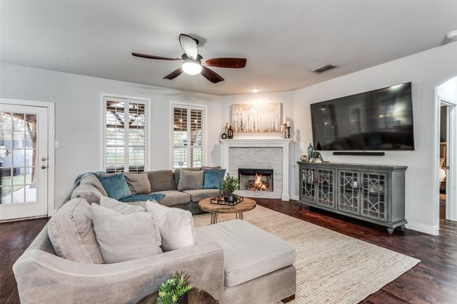 Living room with a ceiling fan, a fireplace, and wood finished floors | Image 12