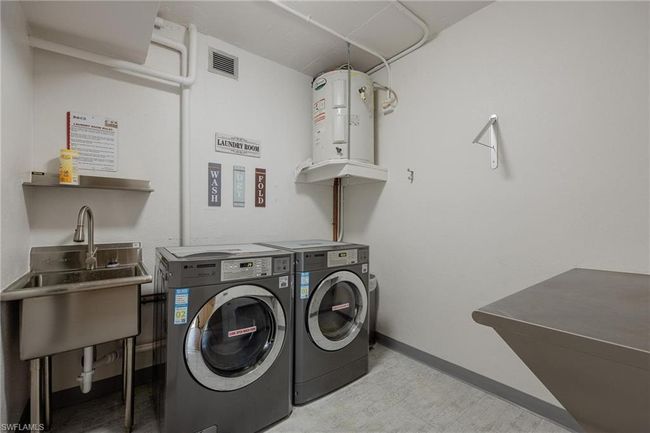 Clothes washing area featuring water heater, sink, and washer and clothes dryer | Image 30