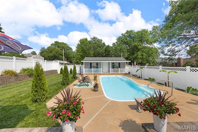 View of swimming pool featuring a patio, a fenced backyard, an outdoor structure, and a storage structure | Image 44