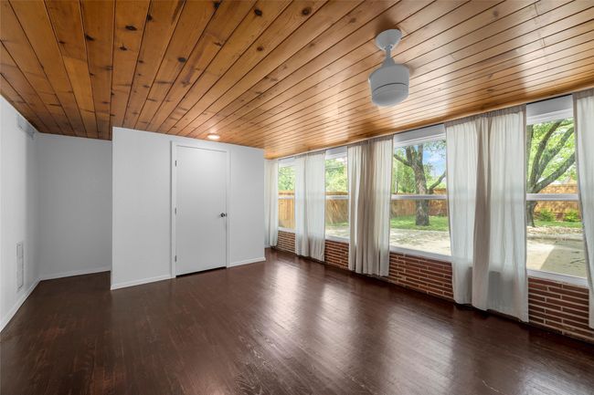 Unfurnished bedroom featuring wooden ceiling, hardwood / wood-style floors, and baseboards | Image 25