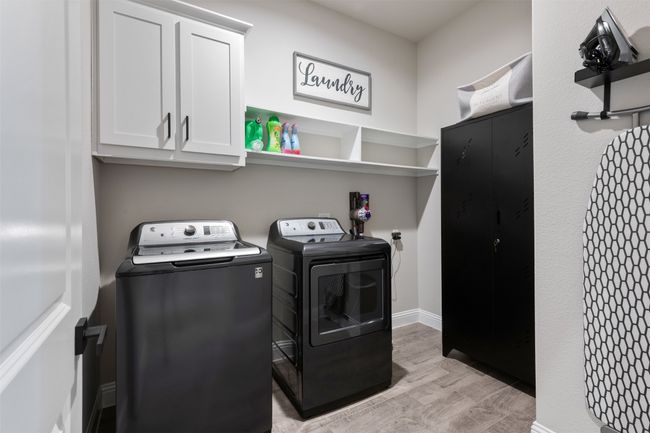 Washroom featuring cabinet space, light wood-style flooring, baseboards, and washer and dryer | Image 8