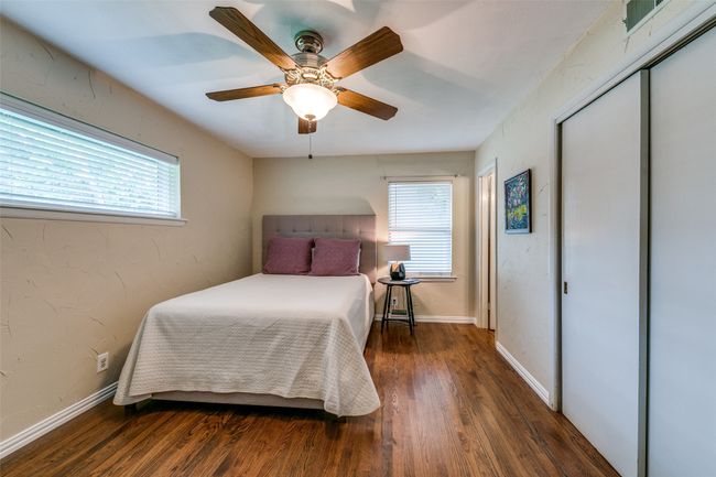 Bedroom featuring multiple windows, wood finished floors, a closet, and ceiling fan | Image 14