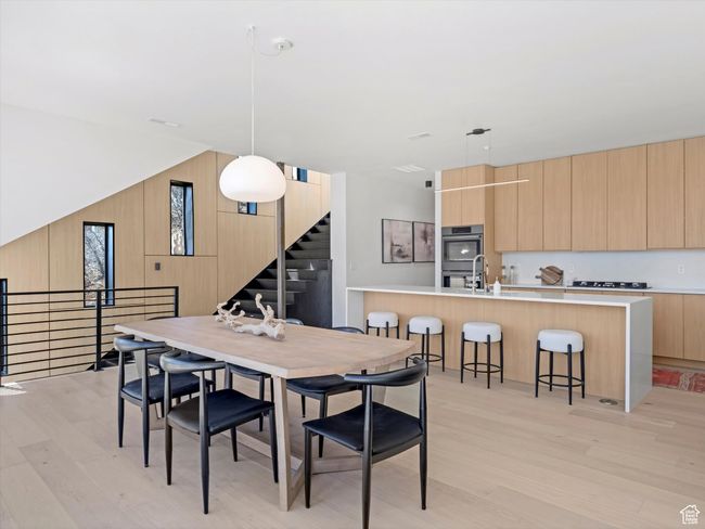 Dining space featuring stairway, light wood-style flooring, and wooden walls | Image 12