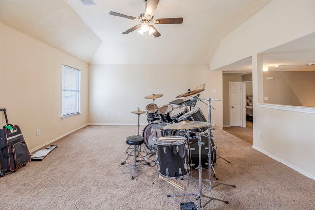 Rec room featuring carpet, vaulted ceiling, a ceiling fan, and baseboards | Image 26