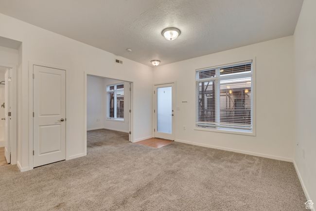 Empty room with baseboards, carpet flooring, a textured ceiling, and visible vents | Image 7