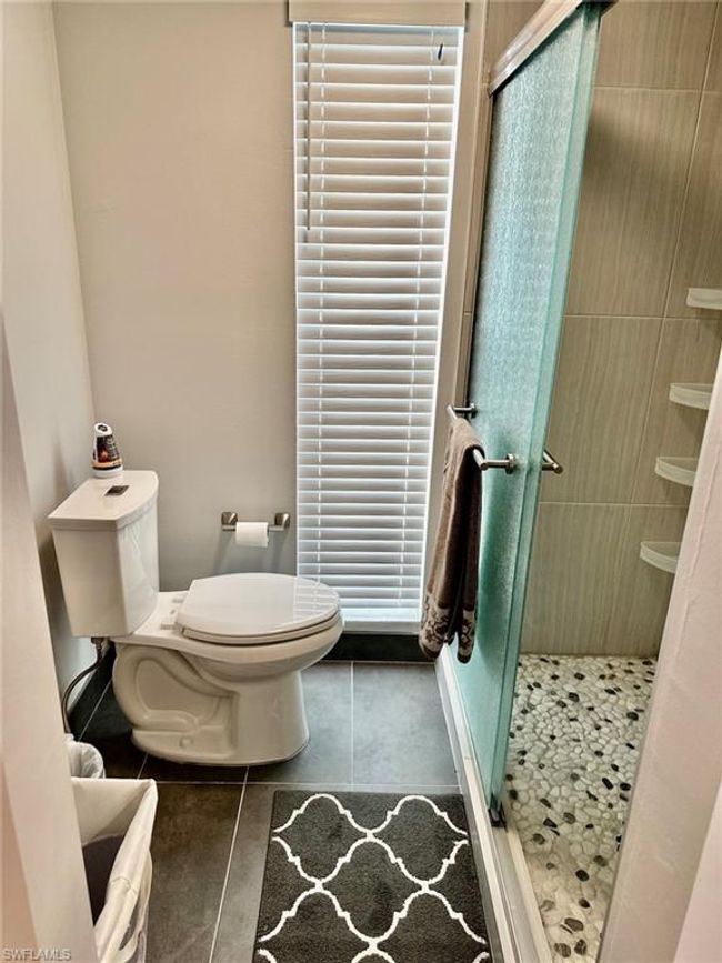Full bathroom with a shower stall, tile patterned flooring, and toilet | Image 14