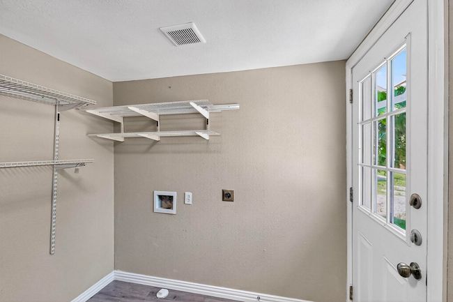 Laundry area with electric dryer hookup, plenty of natural light, hookup for a washing machine, and wood finished floors | Image 9