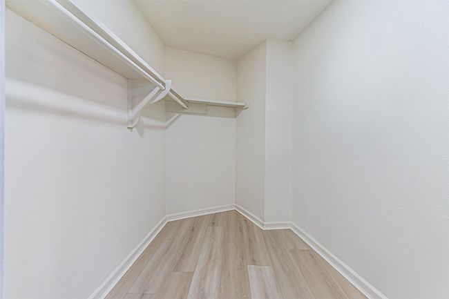 Walk in closet with light hardwood / wood-style flooring | Image 37