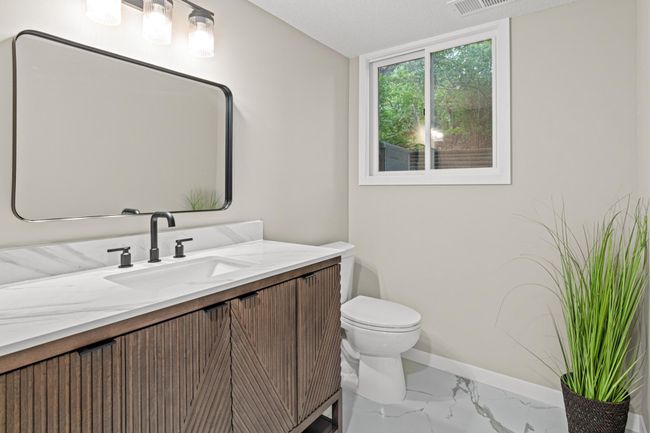 Fully updated lower level 3/4 bathroom with new flooring, trim work, vanity, mirror, lights and shower surround. | Image 20