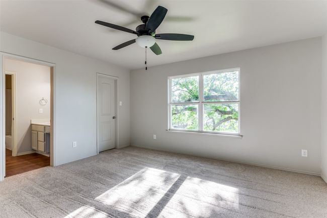 Unfurnished bedroom featuring carpet, ensuite bath, and ceiling fan | Image 33