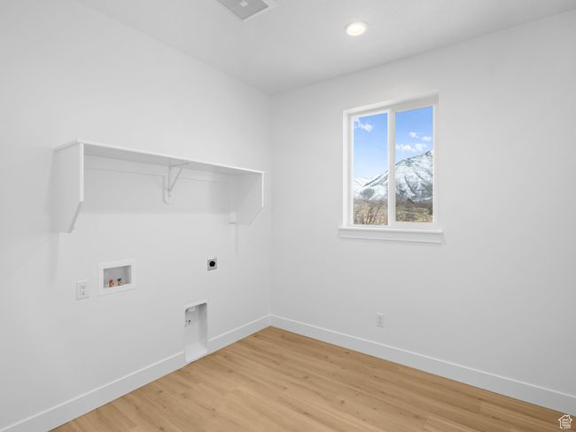 Laundry area featuring light wood finished floors, washer hookup, electric dryer hookup, laundry area, and baseboards | Image 10