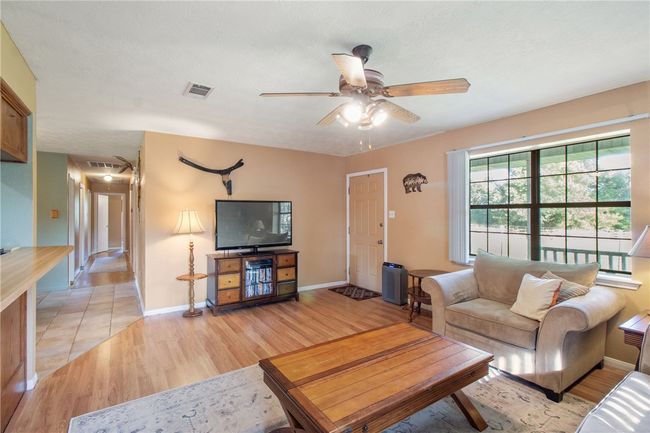 Living room featuring light wood-style flooring and a ceiling fan | Image 14