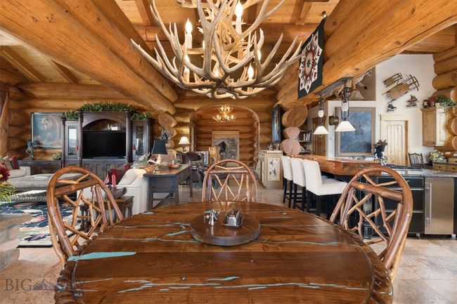 Dining area with antler chandelier and custom table with inlaid turquoise and accompanying lazy susan. | Image 36