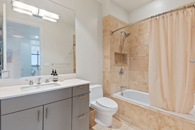 Spa bath showcases a large soaking tub, natural stone surround with storage. | Image 21