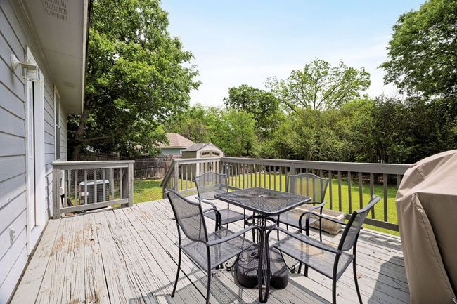 Wooden terrace featuring outdoor dining area, an outdoor structure, a yard, a fenced backyard, and a storage shed | Image 30