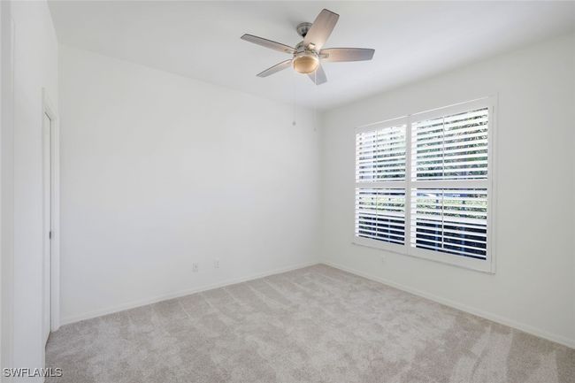 Carpeted room with ceiling fan and baseboards | Image 14