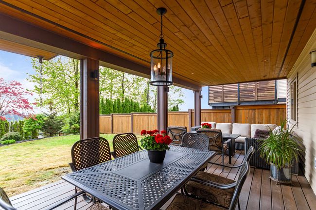 Deck featuring a yard, a fenced backyard, an outdoor hangout area, and outdoor dining space | Image 28