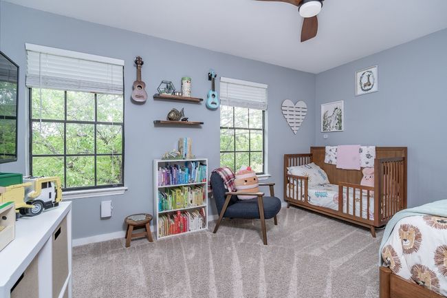 Carpeted bedroom with a ceiling fan, baseboards, and multiple windows for excellent lighting. | Image 22