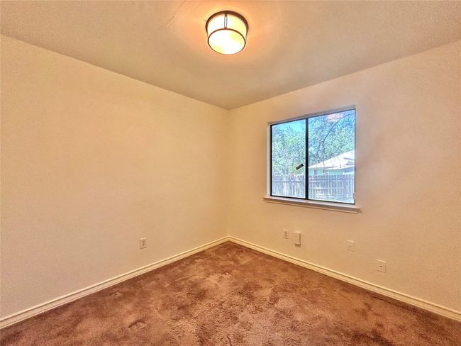 Unfurnished room featuring dark colored carpet and baseboards | Image 14