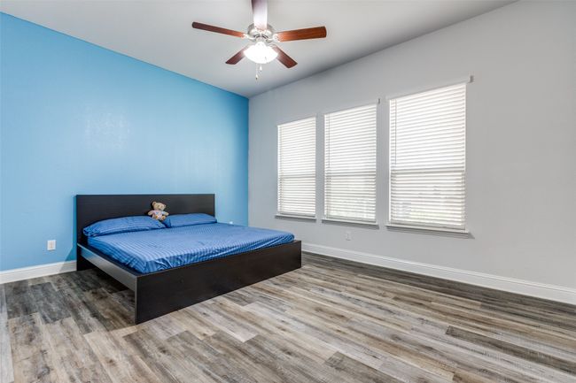Bedroom featuring ceiling fan, baseboards, and wood finished floors | Image 19