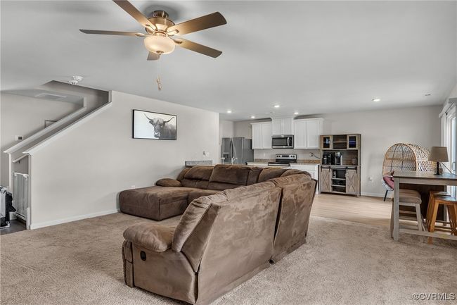 Living room with stairs, light carpet, baseboards, ceiling fan, and recessed lighting | Image 6