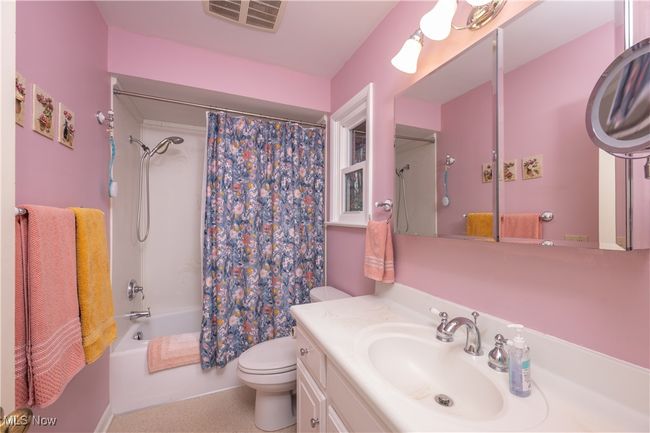 Full bathroom featuring shower / bath combo, visible vents, toilet, and vanity | Image 26
