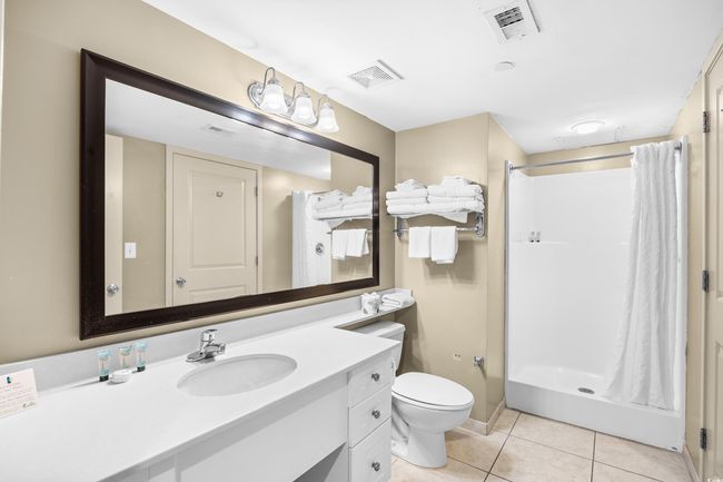 Full bath with a stall shower, tile patterned floors, vanity, and visible vents | Image 19