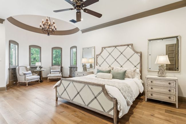 The Expansive Primary Bedroom Boasts Beautiful Wood Plank Floors and a Relaxing Sitting Area | Image 17