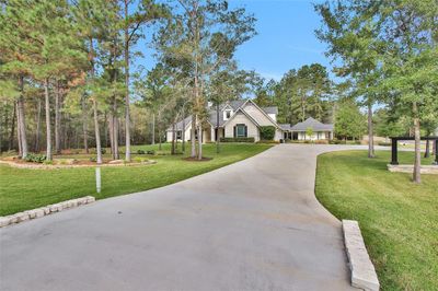 A long driveway welcomes you to this expansive 2-acre property, beautifully situated on a corner lot. | Image 2