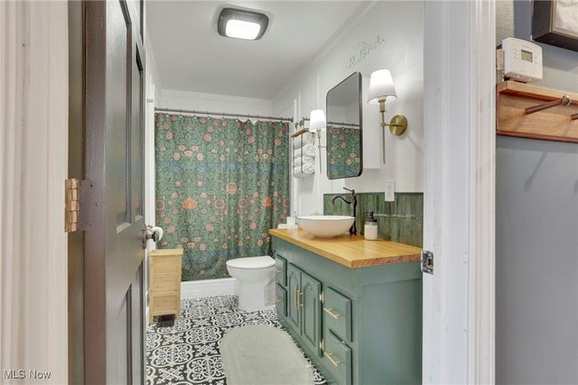 Bathroom with vanity, tile patterned flooring, and a shower with shower curtain | Image 17