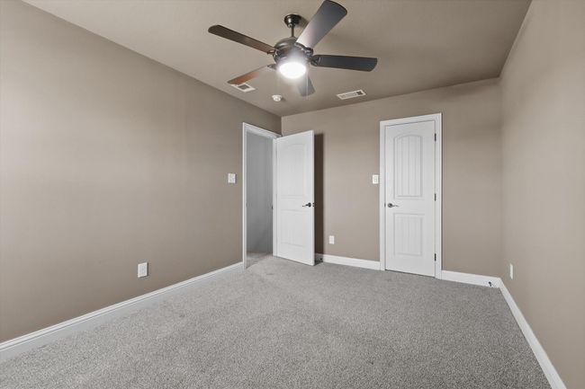 Unfurnished bedroom with carpet flooring, baseboards, and a ceiling fan | Image 24