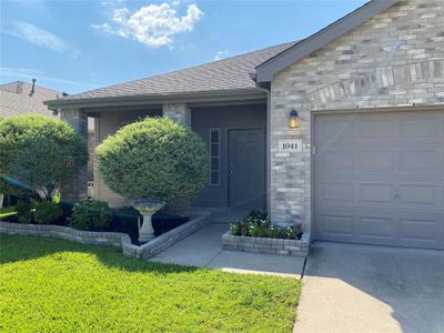 View of exterior entry featuring a garage and a lawn | Image 3