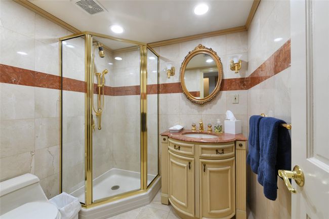 Bathroom with a shower stall, tile walls, and visible vents | Image 18
