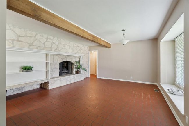 Unfurnished living room featuring brick floors and a fireplace | Image 7