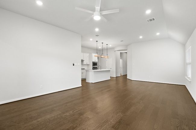 Unfurnished living room featuring vaulted ceiling, recessed lighting, dark wood-style flooring, and ceiling fan | Image 13