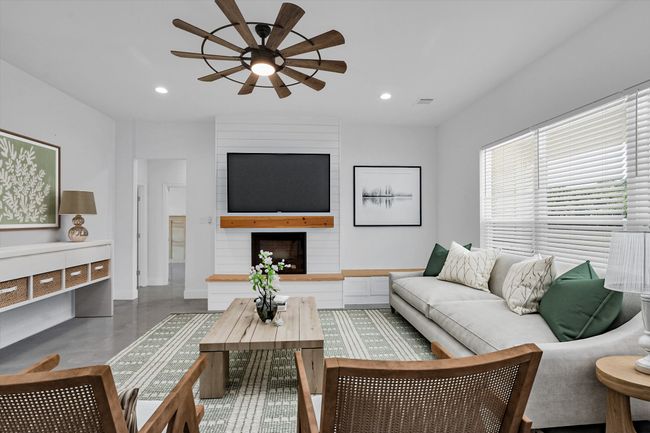Living room featuring a ceiling fan, concrete floors, recessed lighting, and a large fireplace | Image 15