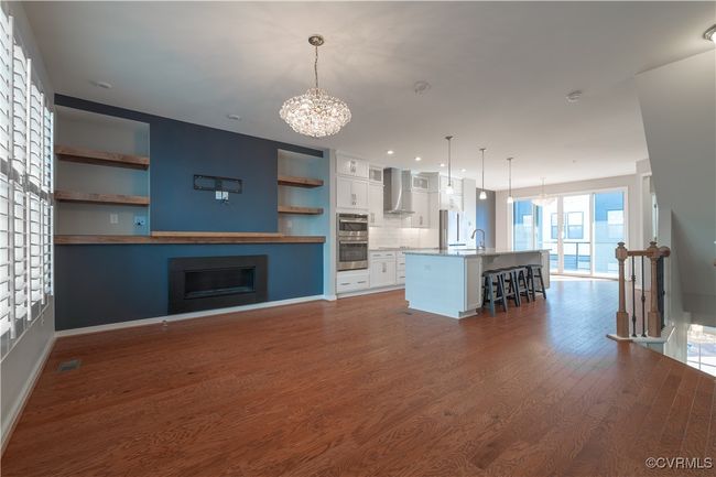 Unfurnished living room featuring dark hardwood / wood-style floors, a notable chandelier, and sink | Image 4