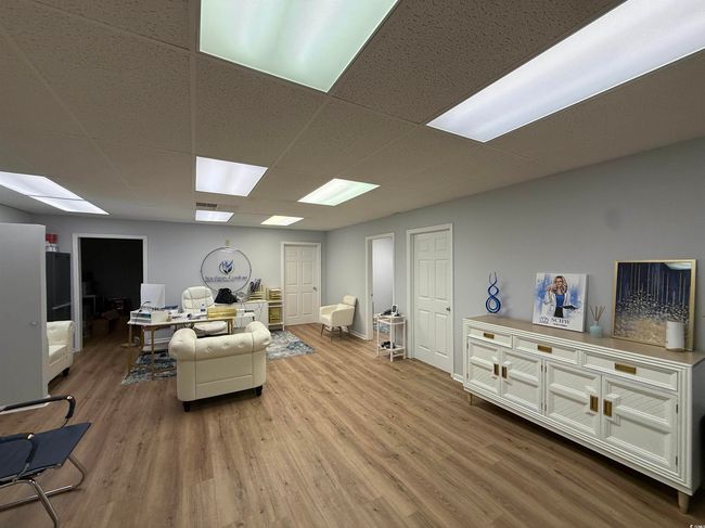 Living room featuring wood finished floors, an office area, and a drop ceiling | Image 5
