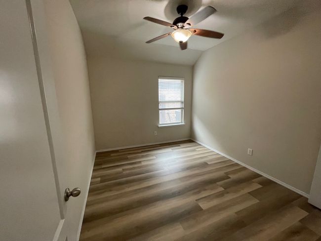 Spare room with ceiling fan, vaulted ceiling, and wood finished floors | Image 22