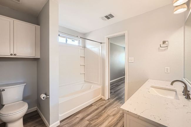 Full bath featuring toilet, vanity, visible vents, and wood finished floors | Image 17