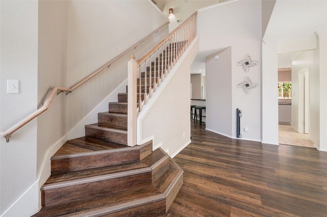 Stairs with baseboards, a high ceiling, and wood finished floors | Image 12