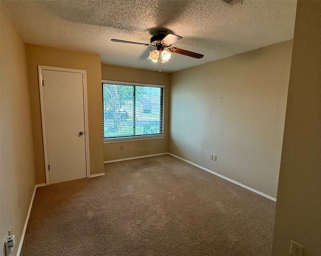 Spare room featuring a ceiling fan, a textured ceiling, carpet flooring, and baseboards | Image 4