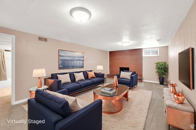 Living room with light carpet, a brick fireplace, and baseboards | Image 16