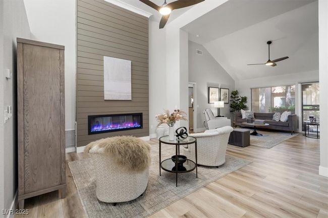 Inside you'll discover soaring majestic ceilings, an open-concept floor plan, sleek pocket windows, & warm natural light. The upgraded interior features luxury flooring, fresh designer paint, & new baseboards. Relax by the linear fireplace or entertain in the formal dining area. | Image 4