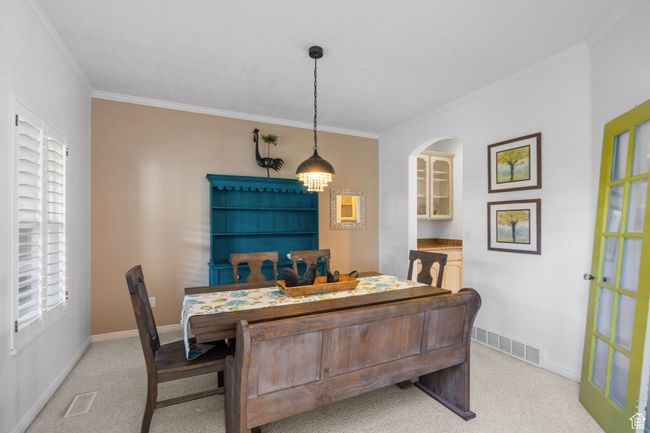 Dining space featuring crown molding, light colored carpet, baseboards, and visible vents | Image 21