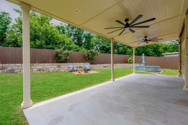 Fenced backyard with a patio and ceiling fan | Image 26