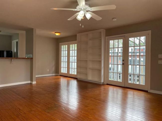 Unfurnished living room with healthy amount of natural light, ceiling fan, and hardwood / wood-style flooring | Image 8